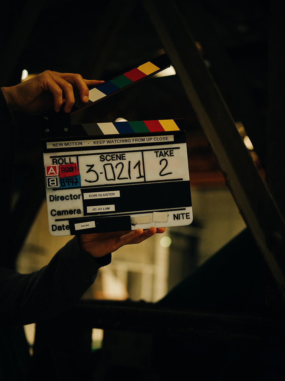 2. Kameraassistenz hält eine Filmklappe und markiert eine Szene am Filmset.